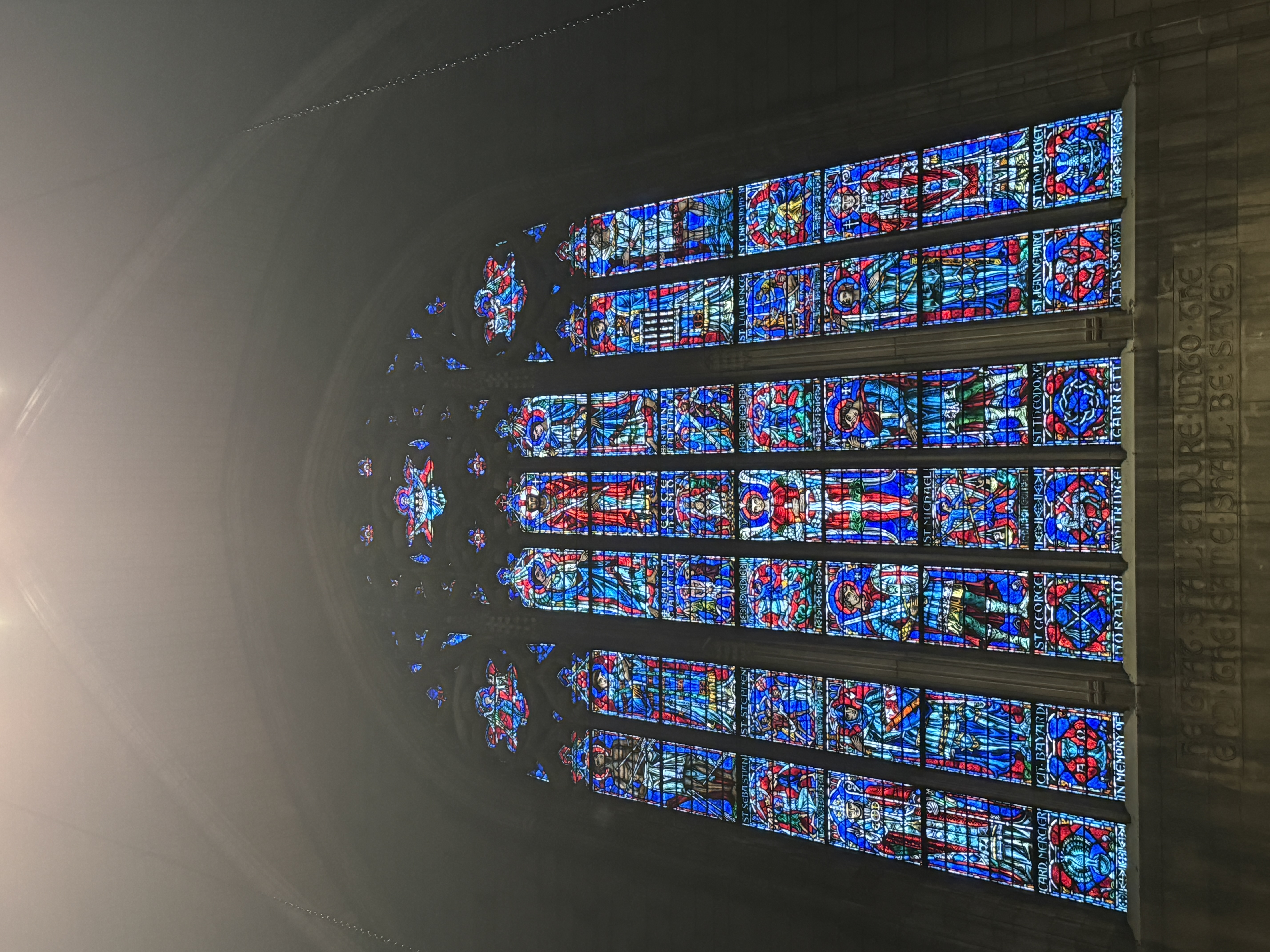 Side view of chapel arches above organ pipes and tall stained-glass windows