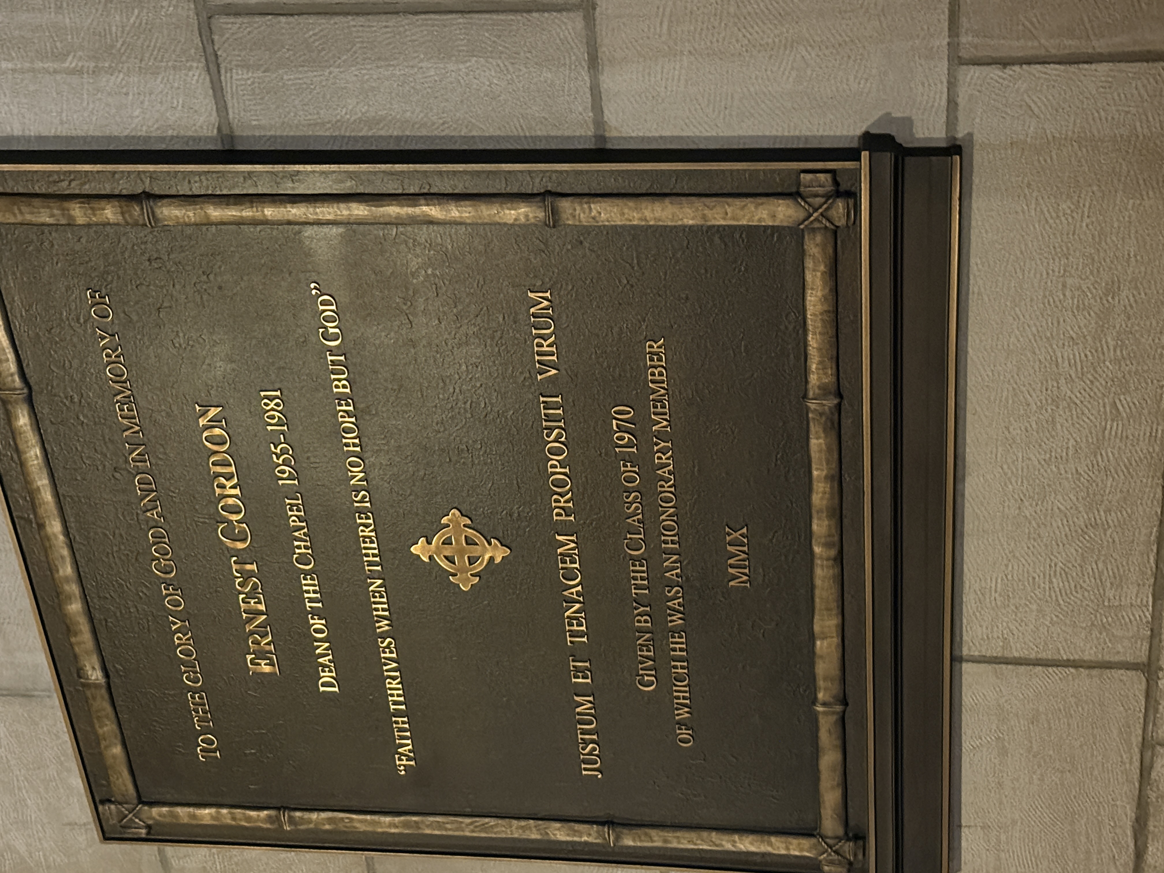 Bronze memorial plaque honoring Ernest Gordon mounted on a stone wall