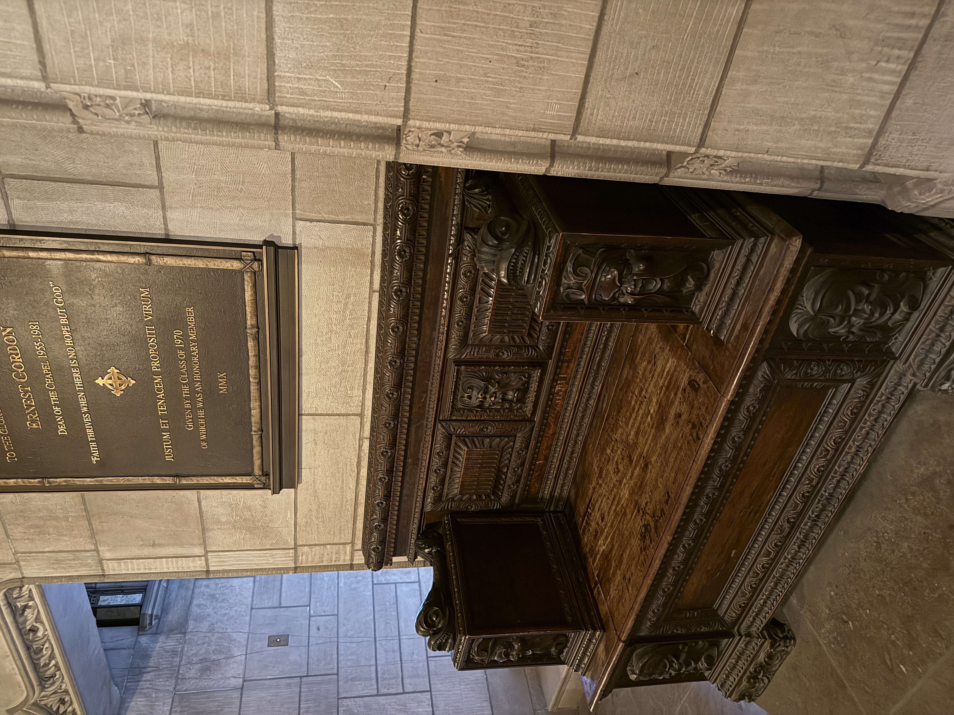 Carved wooden bench or chest placed below the Ernest Gordon memorial plaque