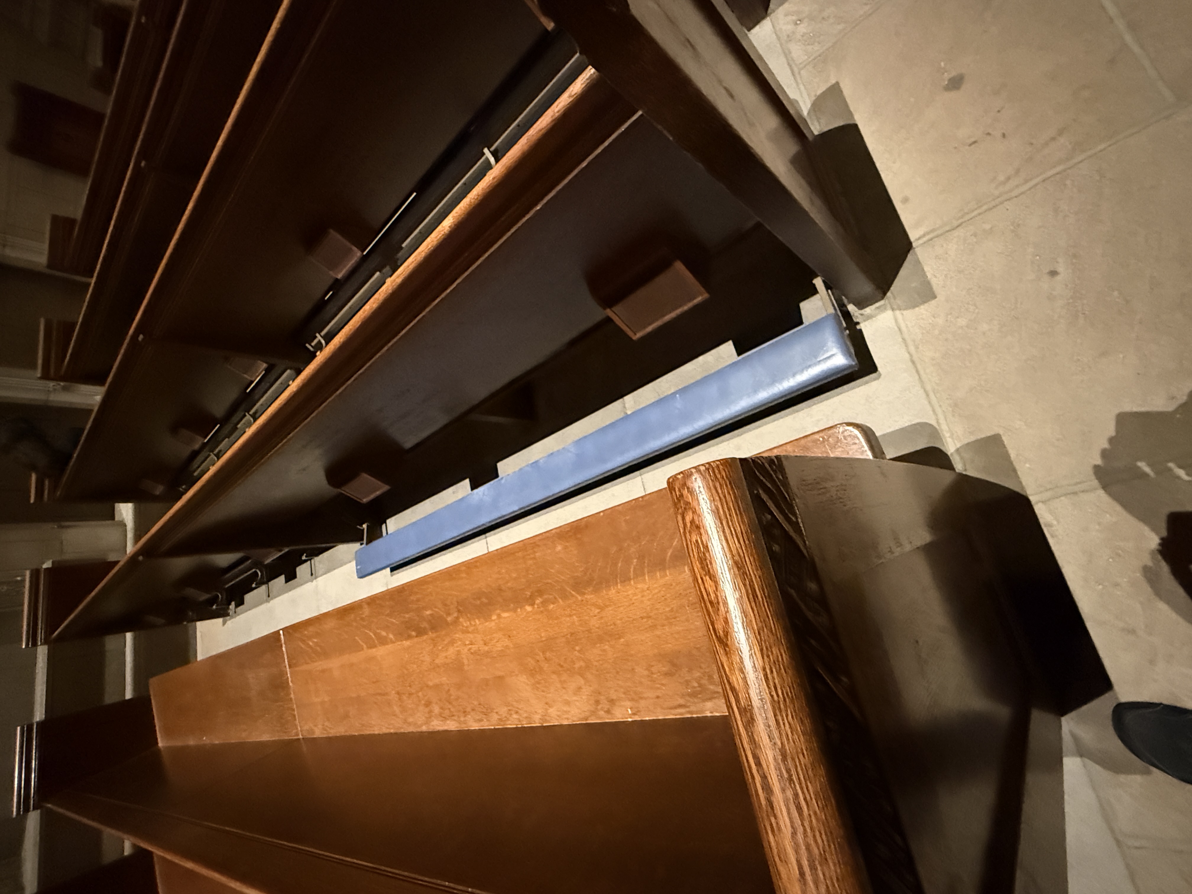 Wooden bench and seat supports viewed from the side inside the chapel