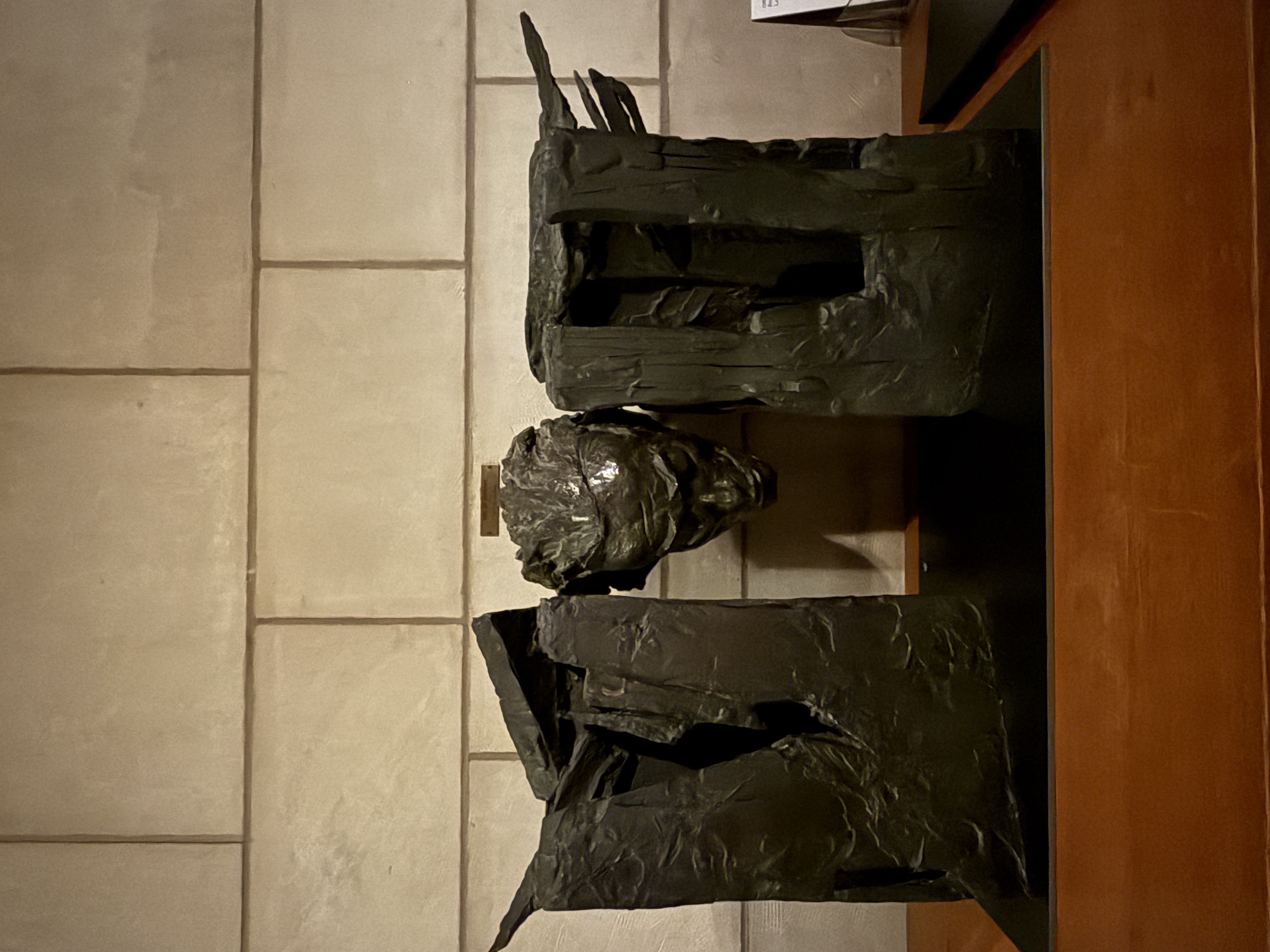 Second view of the abstract bronze sculpture with central head and tall forms