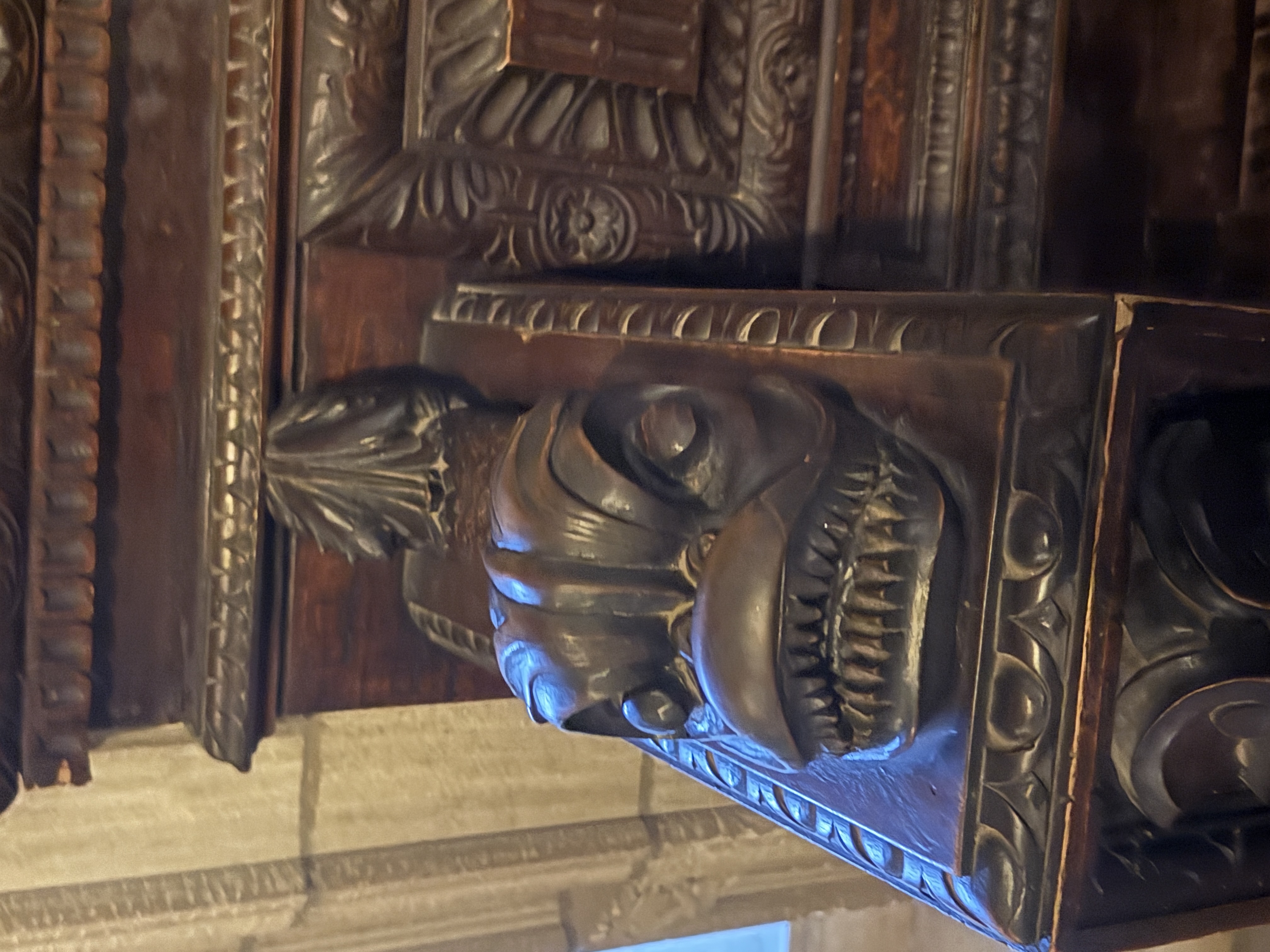 Close-up of a carved grotesque face on the chapel woodwork