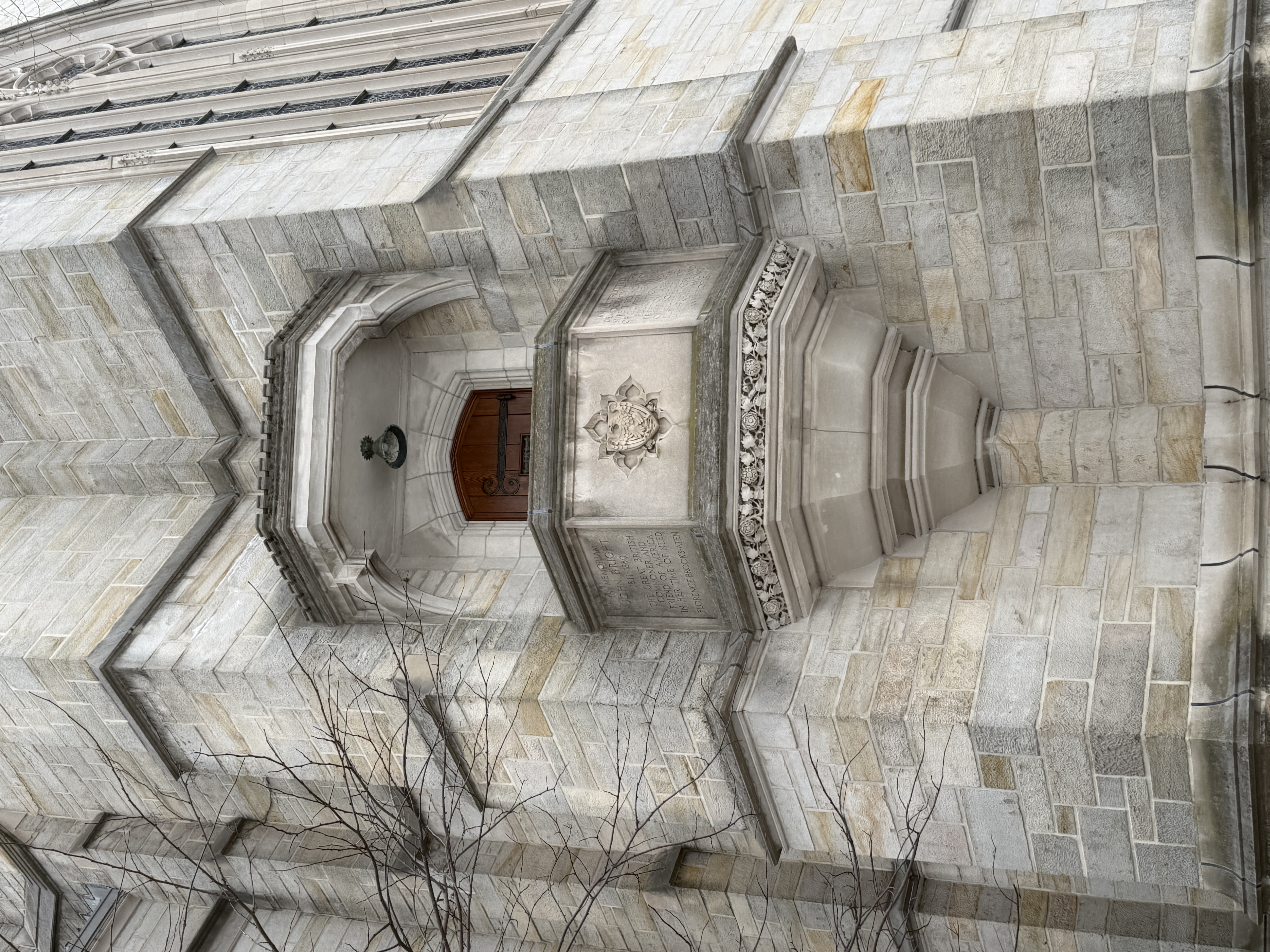 Projecting stone exterior niche with a small recessed doorway and lamp