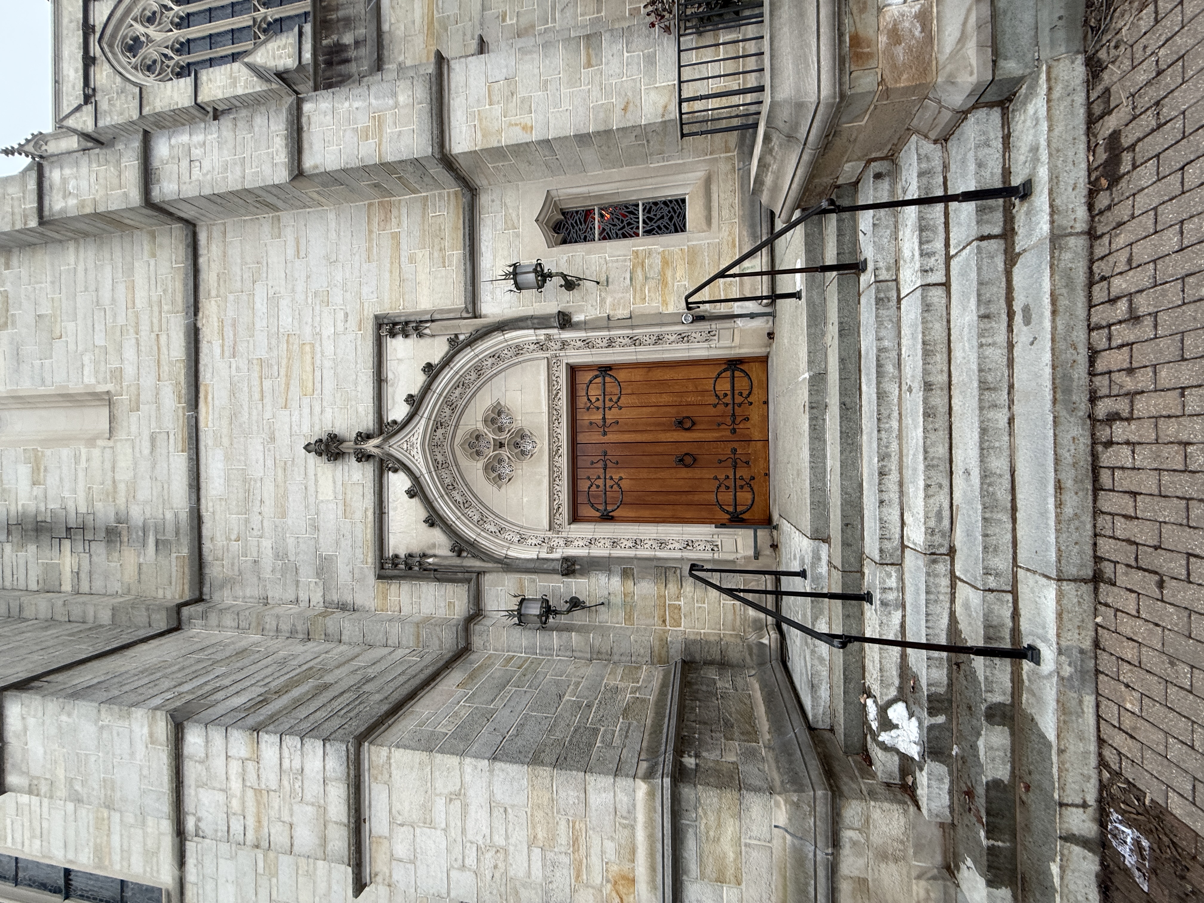 Side entrance door at the top of short stone steps with black handrails