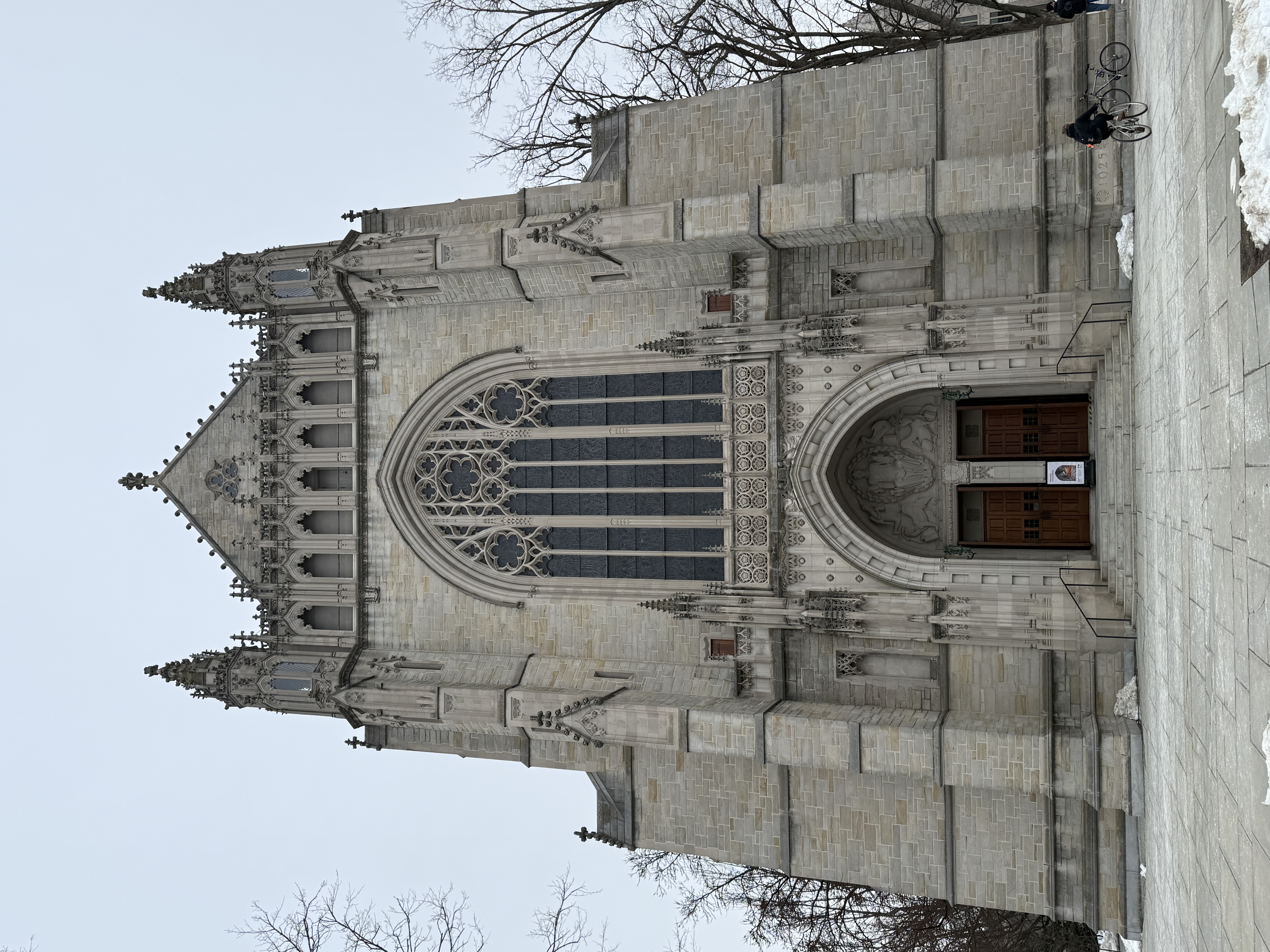 Front facade of the chapel with a large central stained-glass window above the main doors