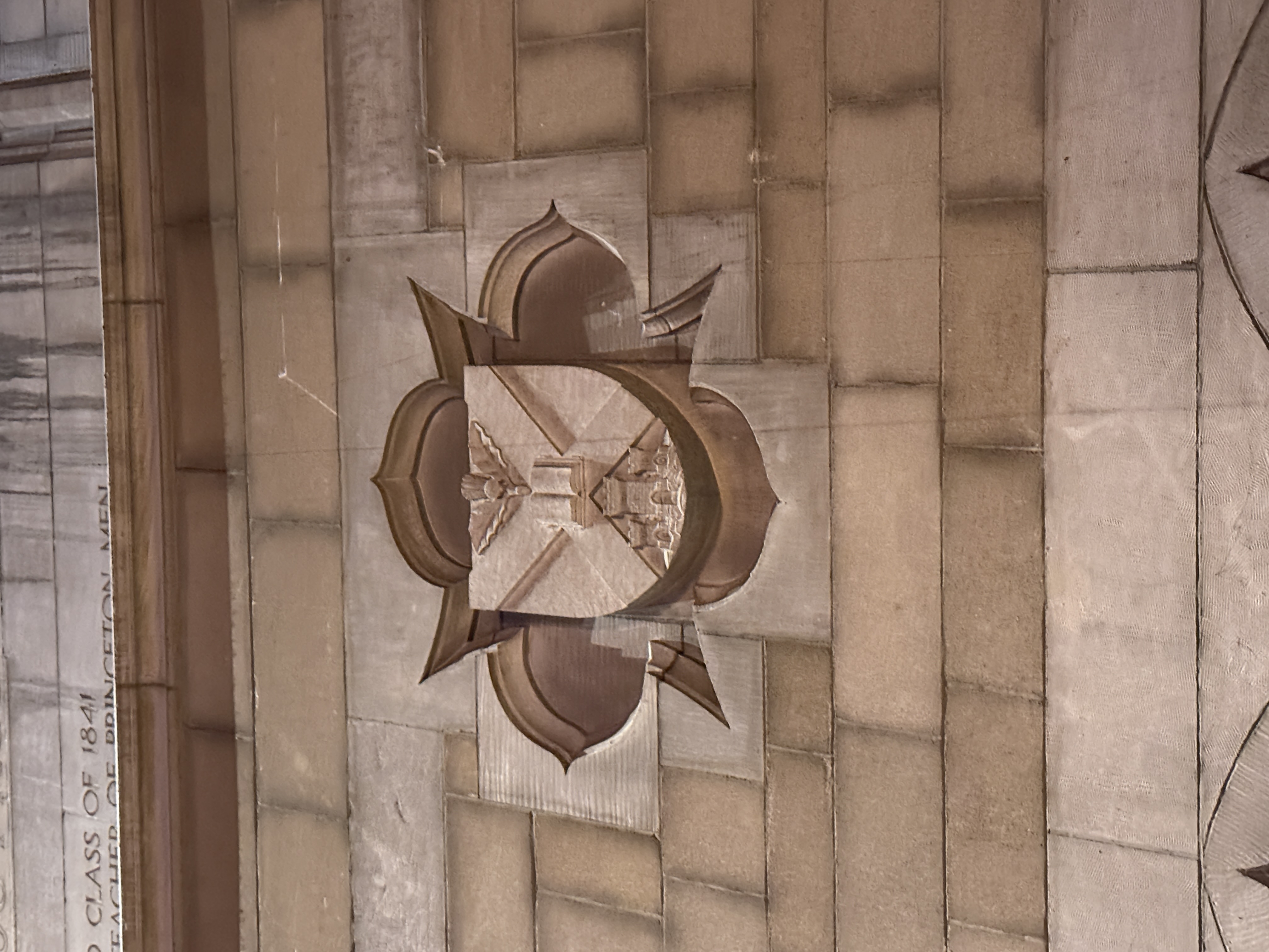 Dark hanging banner with a blue shield emblem mounted on the chapel wall