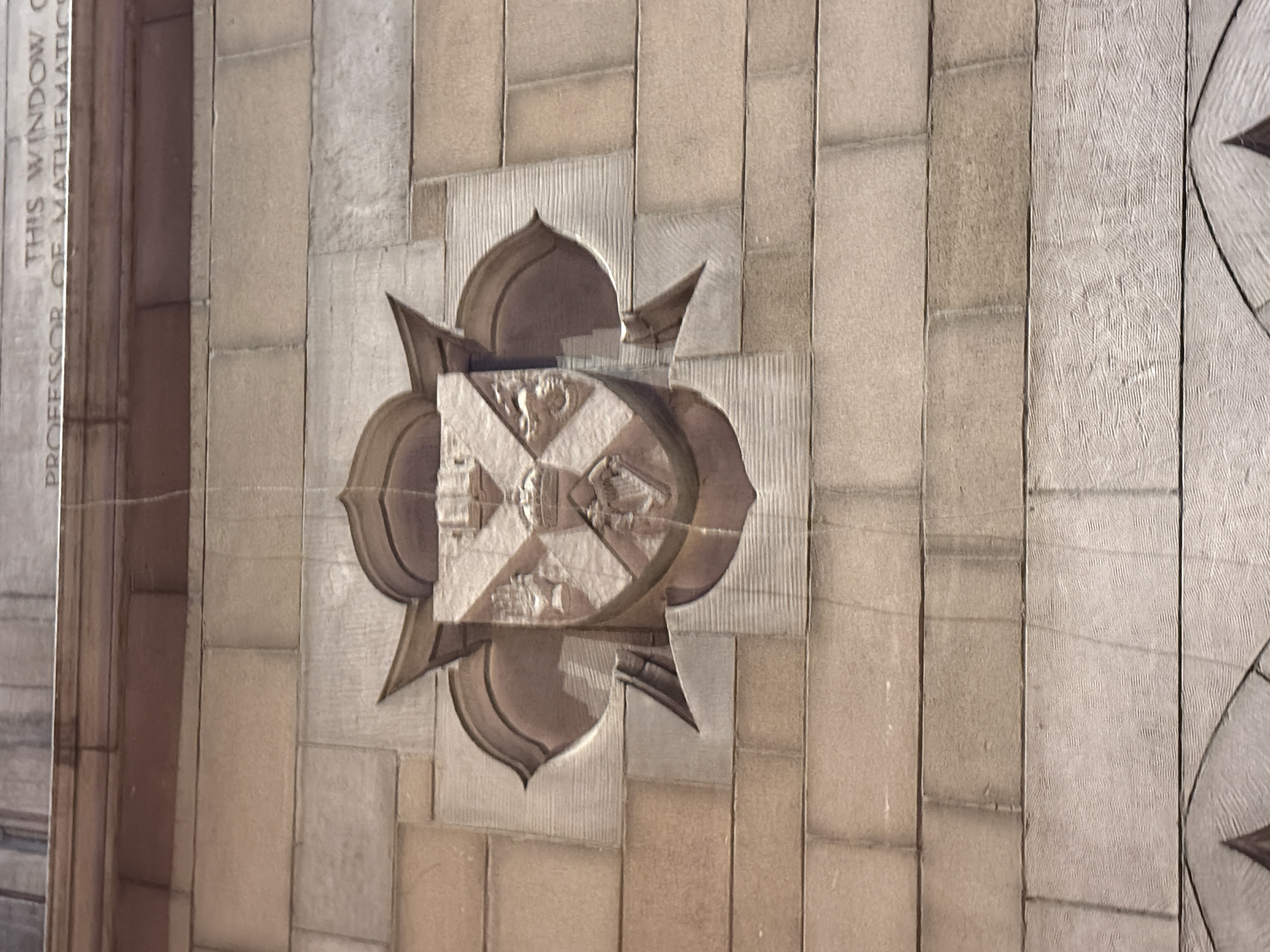 Carved stone shield with diagonal bands and small heraldic figures