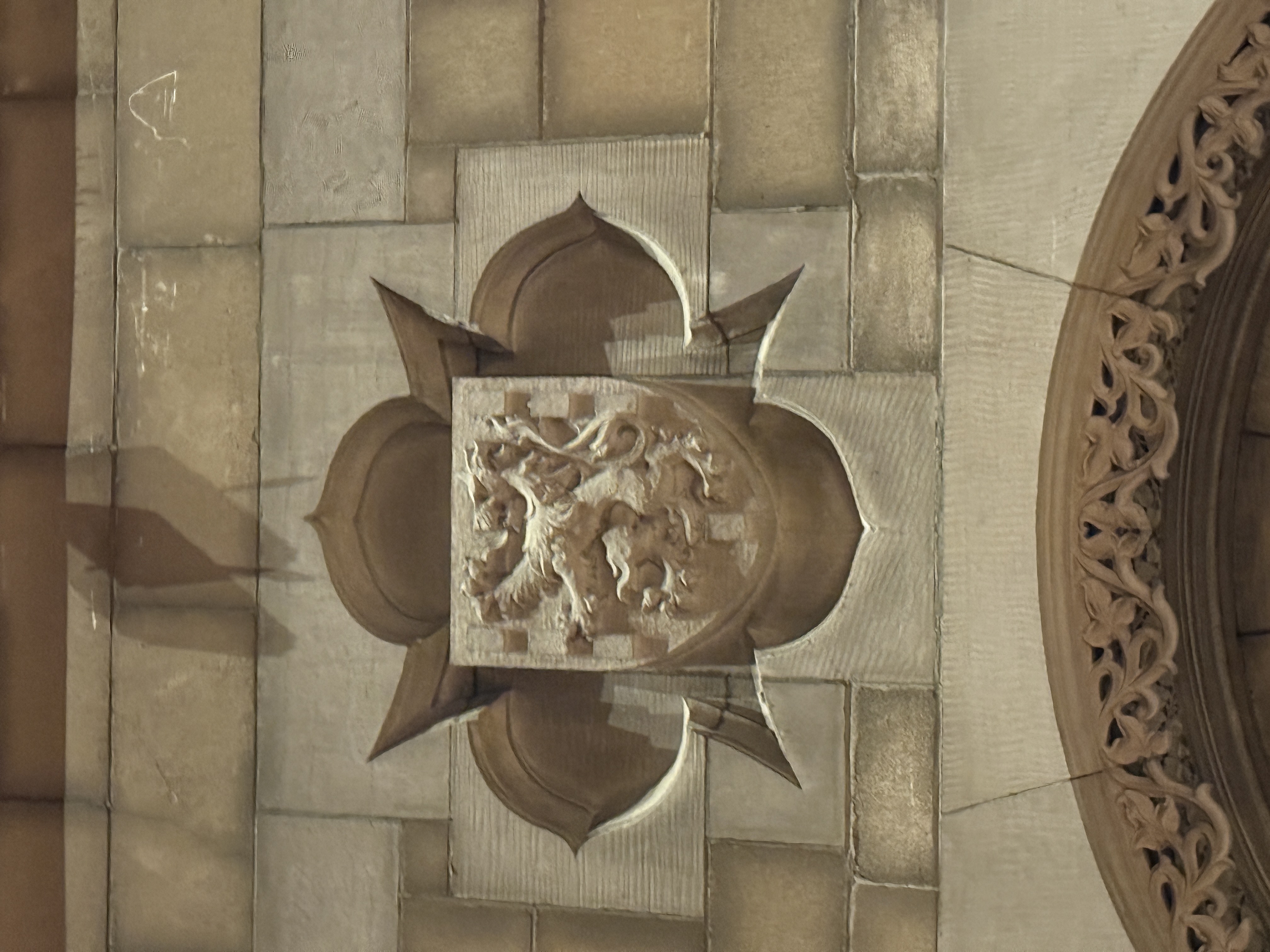 Stone shield with horizontal bands beside an ornate carved doorway surround