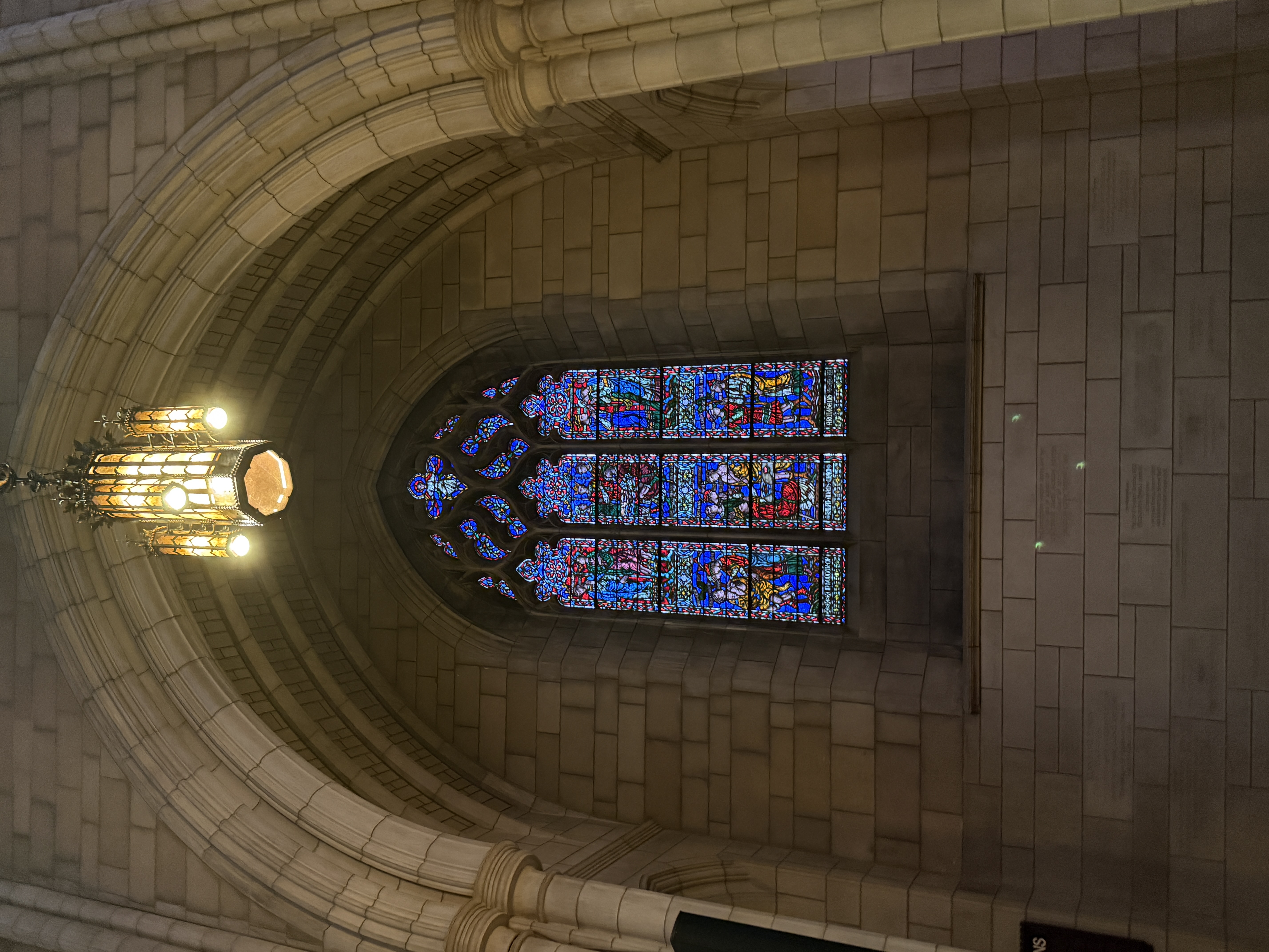 Large stained-glass window with multiple saints in stacked vertical panels