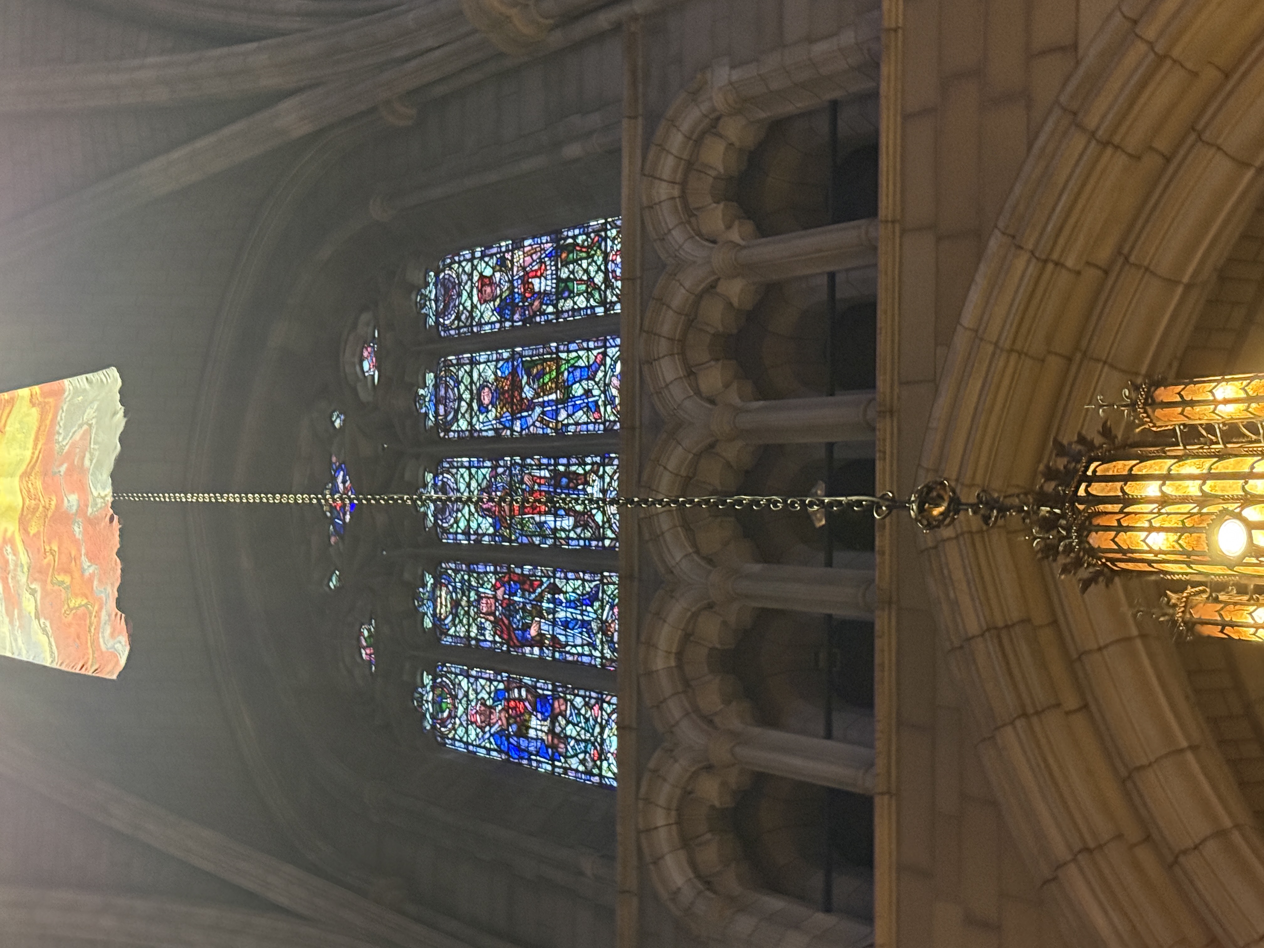 Close view of stained-glass figures in blue robes with red ornamental borders
