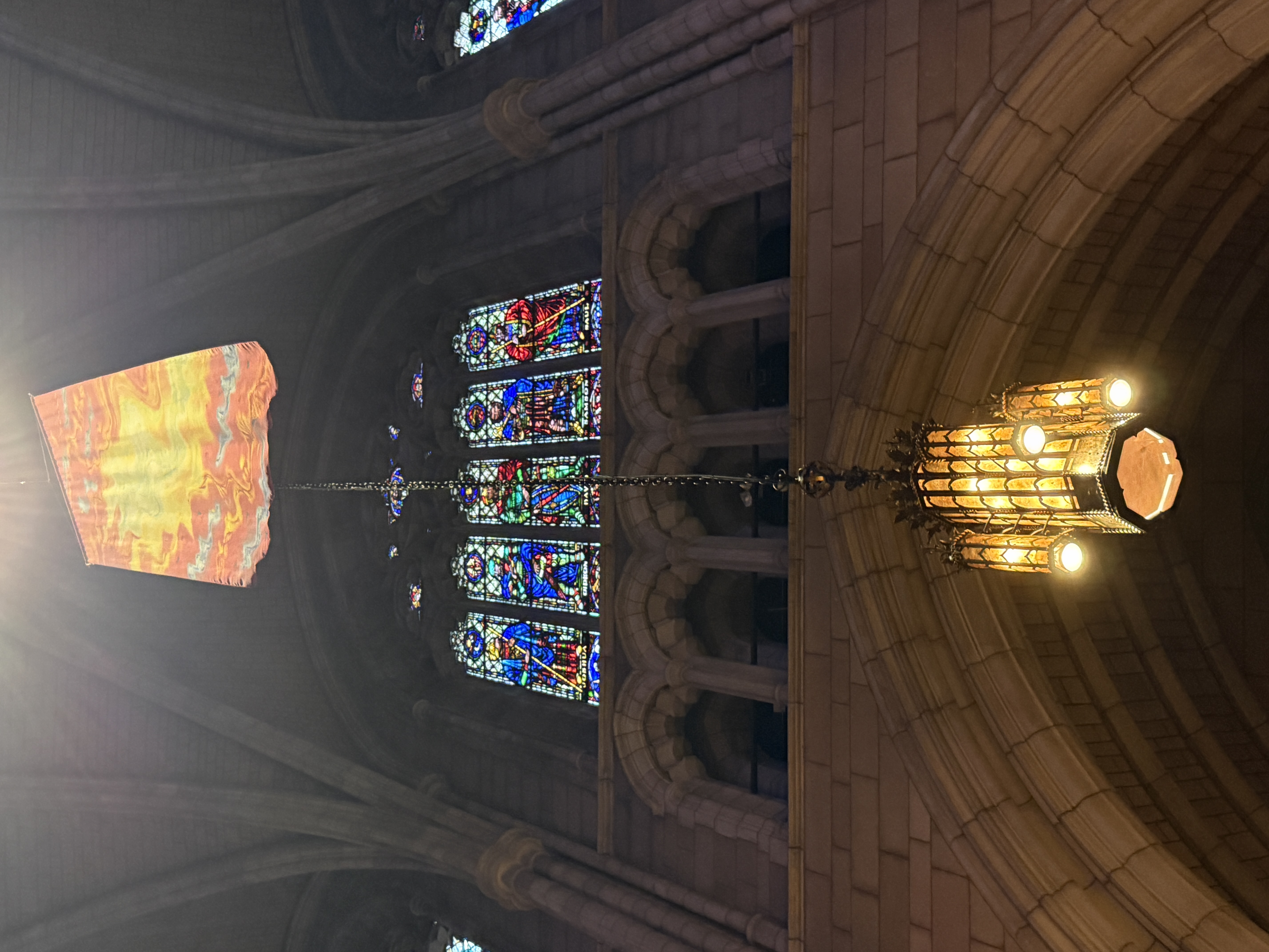 Blue and red stained-glass lancet window set into a deep stone arch