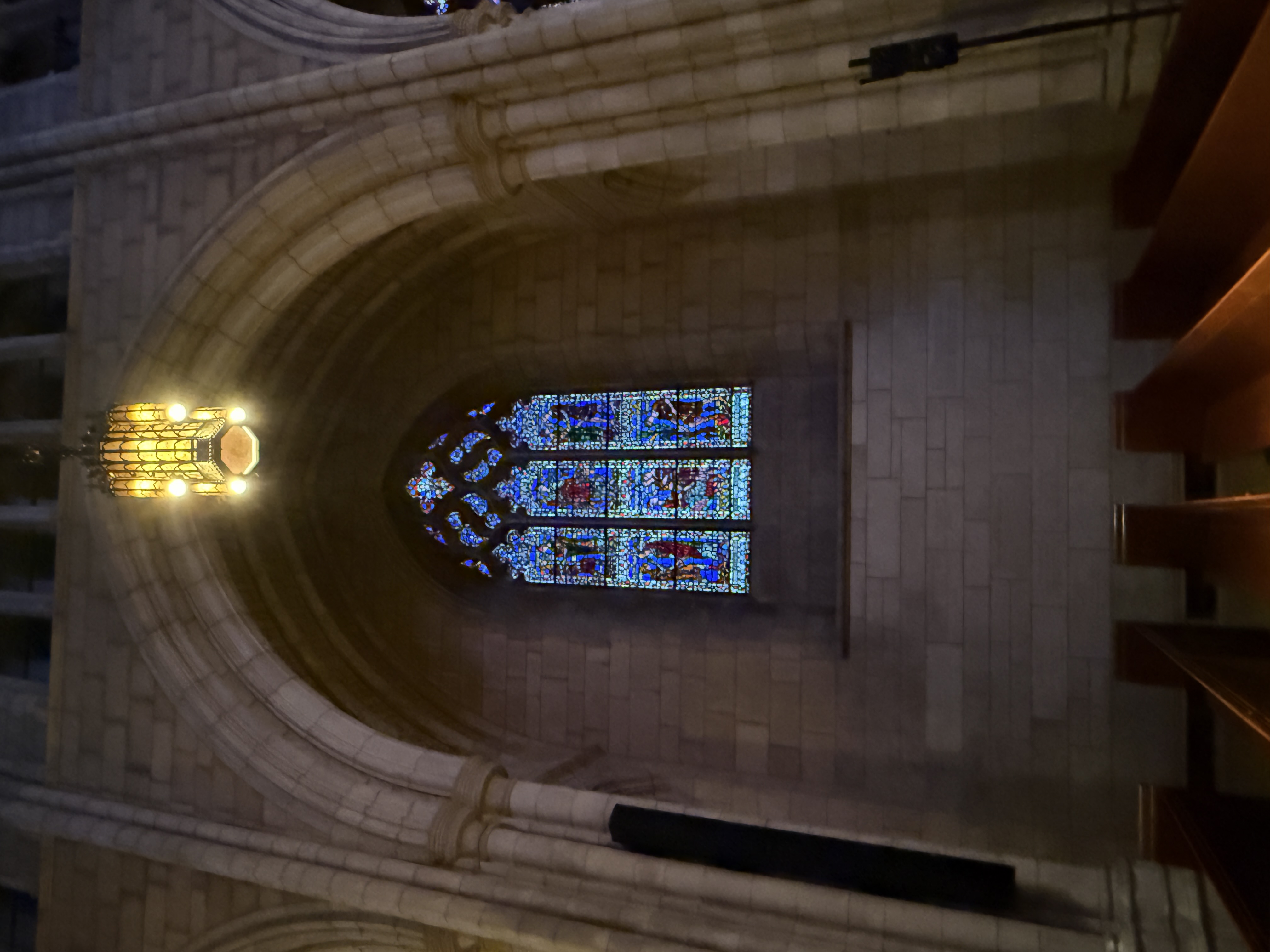 Wide sanctuary view with stained-glass windows illuminating the nave