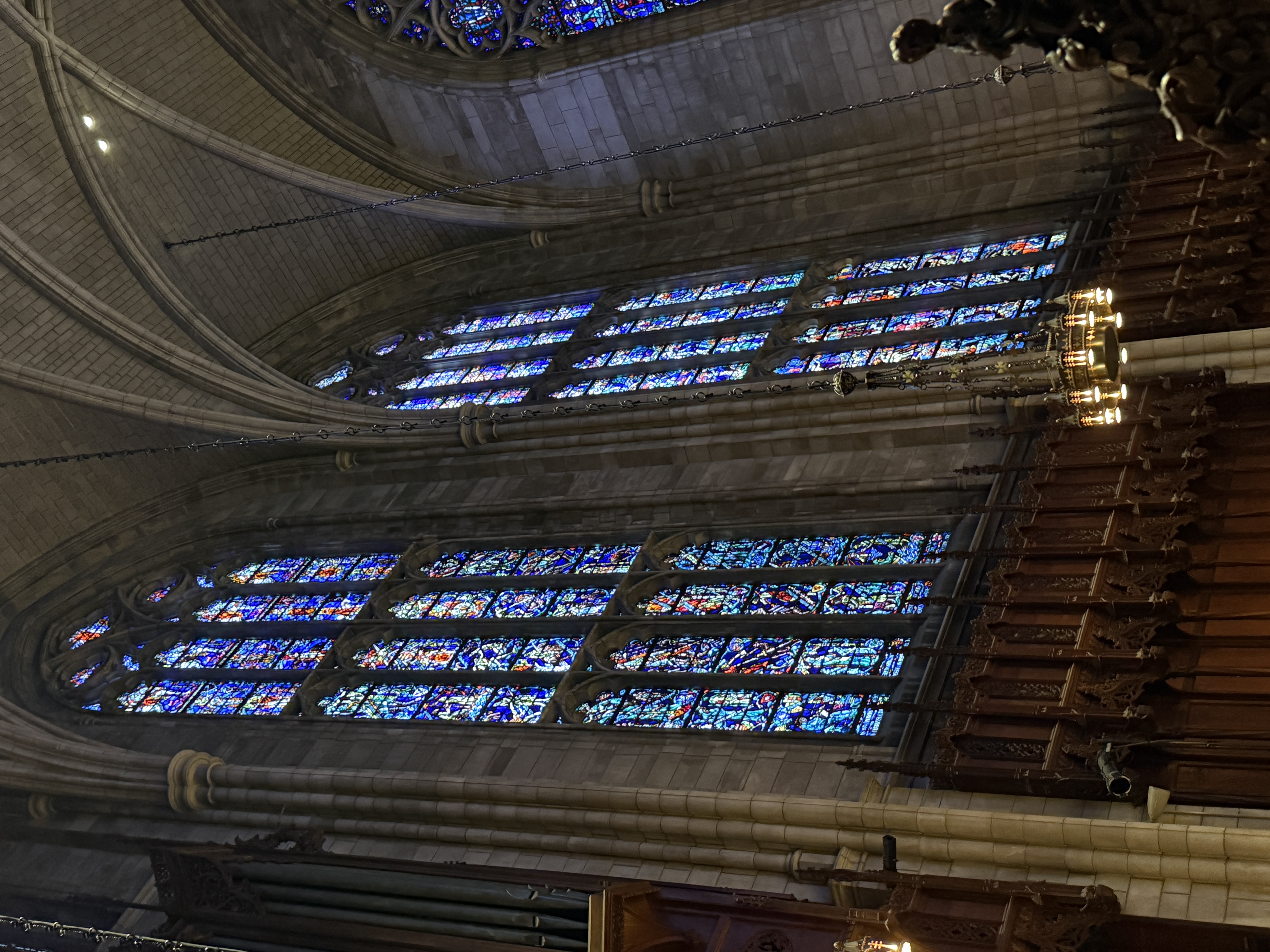 Small chapel altar framed by tall stained-glass windows and dark wood paneling