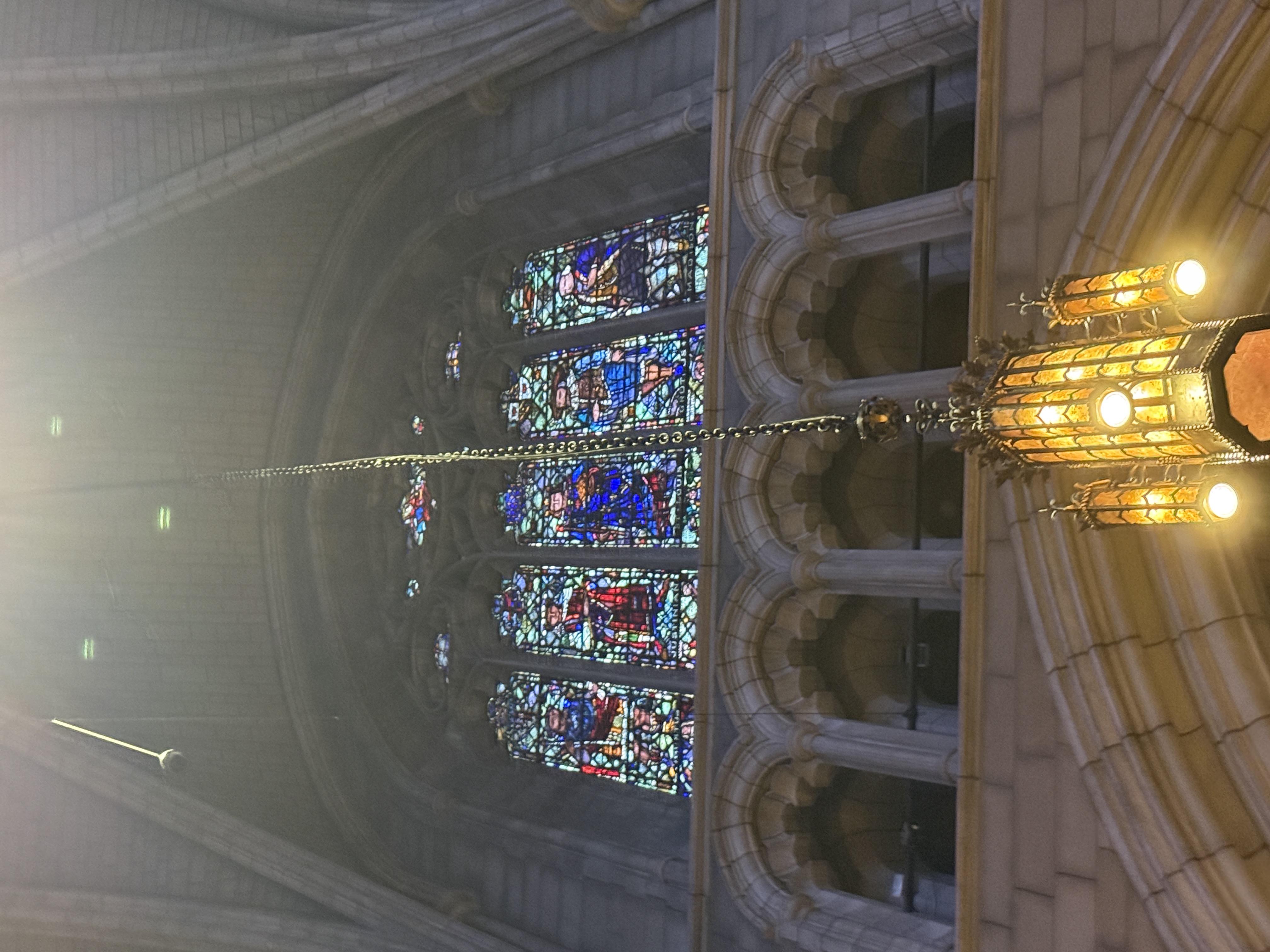 Three-panel stained-glass composition with saints under pointed Gothic arches