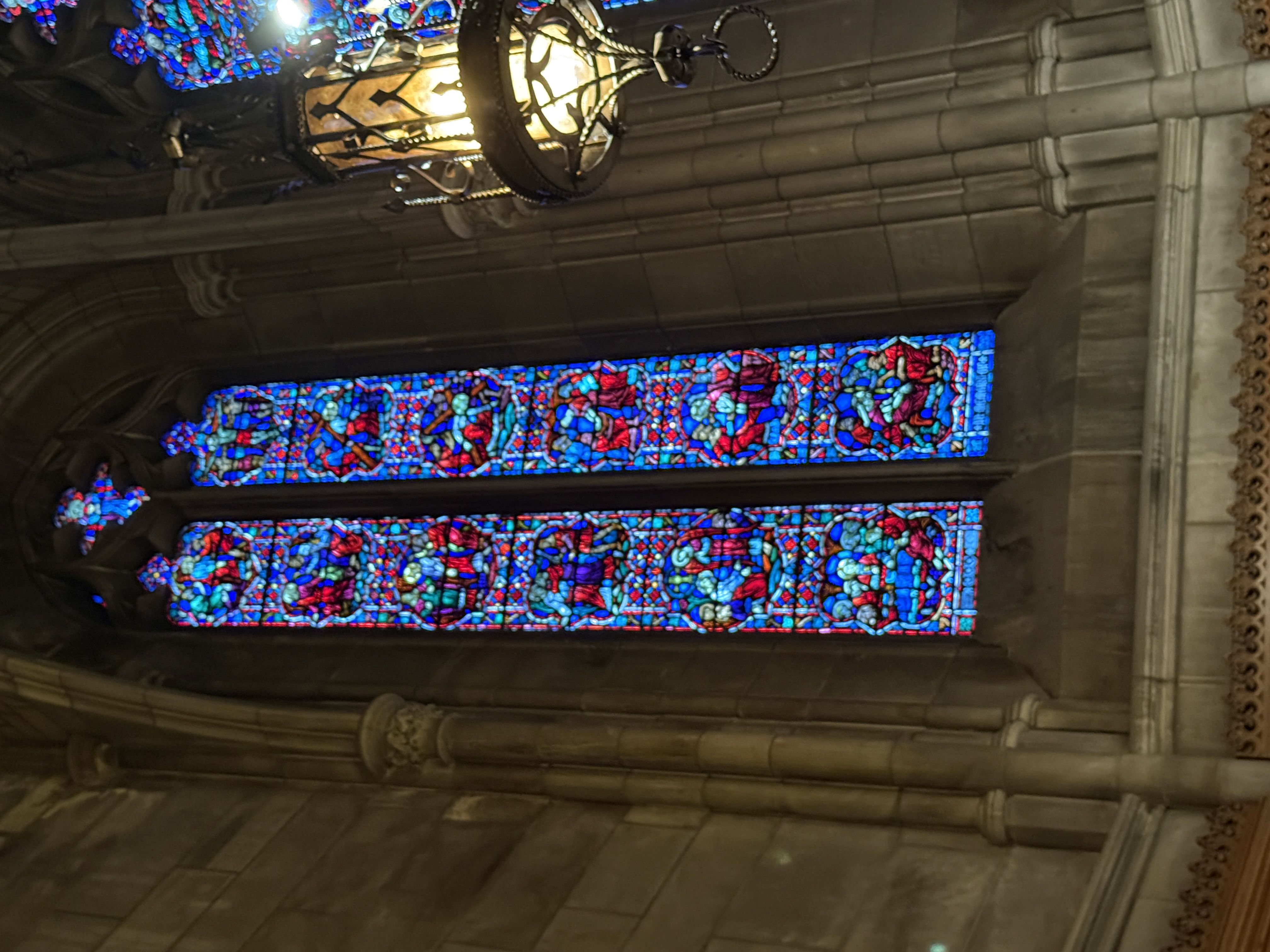 Vertical stained-glass window with dense blue and red geometric panels