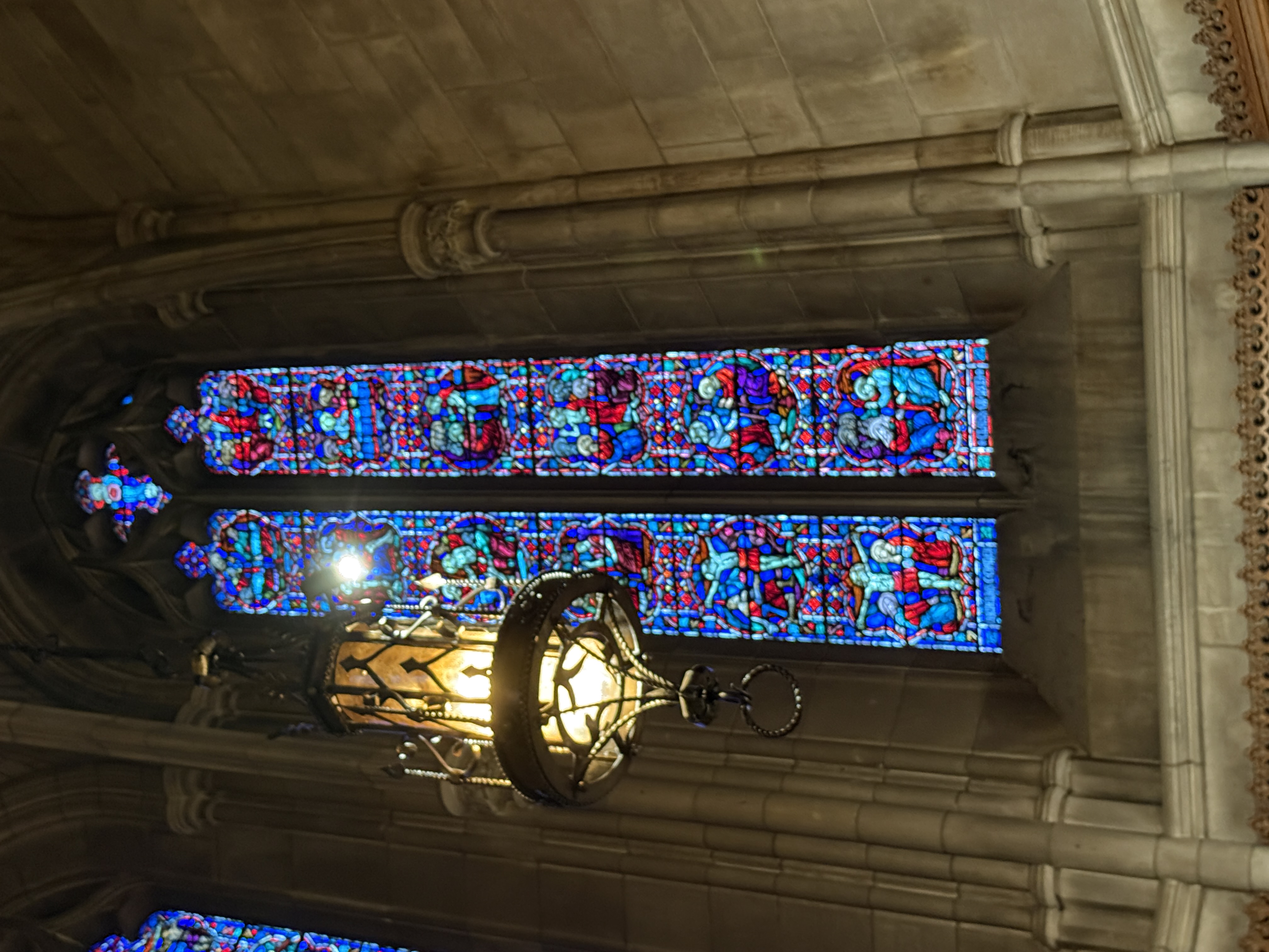 Carved wooden pulpit with glowing stained-glass windows in the background